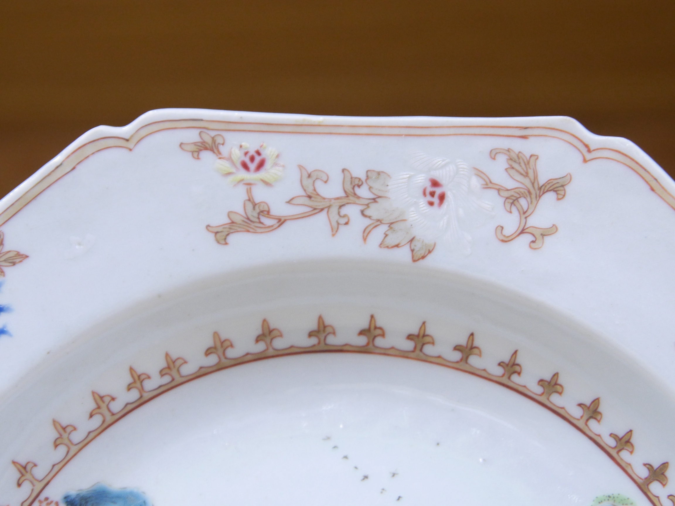 An 18th century Chinese famille rose 'landscape' octagonal plate, 22cm wide. Condition - good, minor chipping